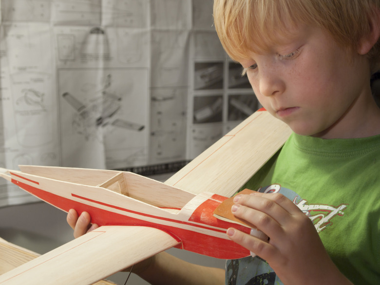 Boy building wooden model airplane