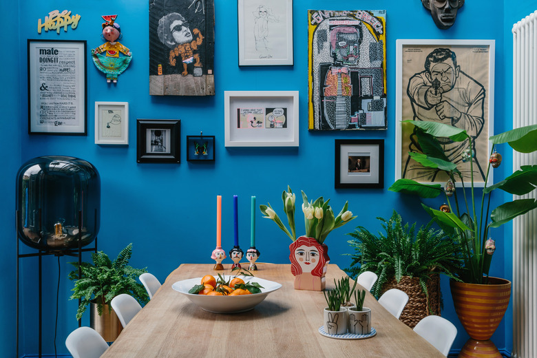 blue dining room color idea with art gallery wall and potted plants