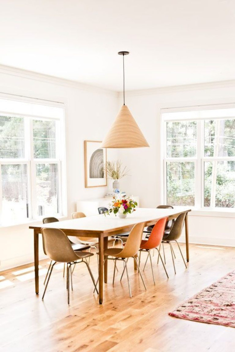 dining room curtain idea with roller shades in white midcentury space with mismatched chairs