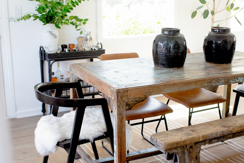 dining room idea with rustic table and mismatched chairs and bar cart near table