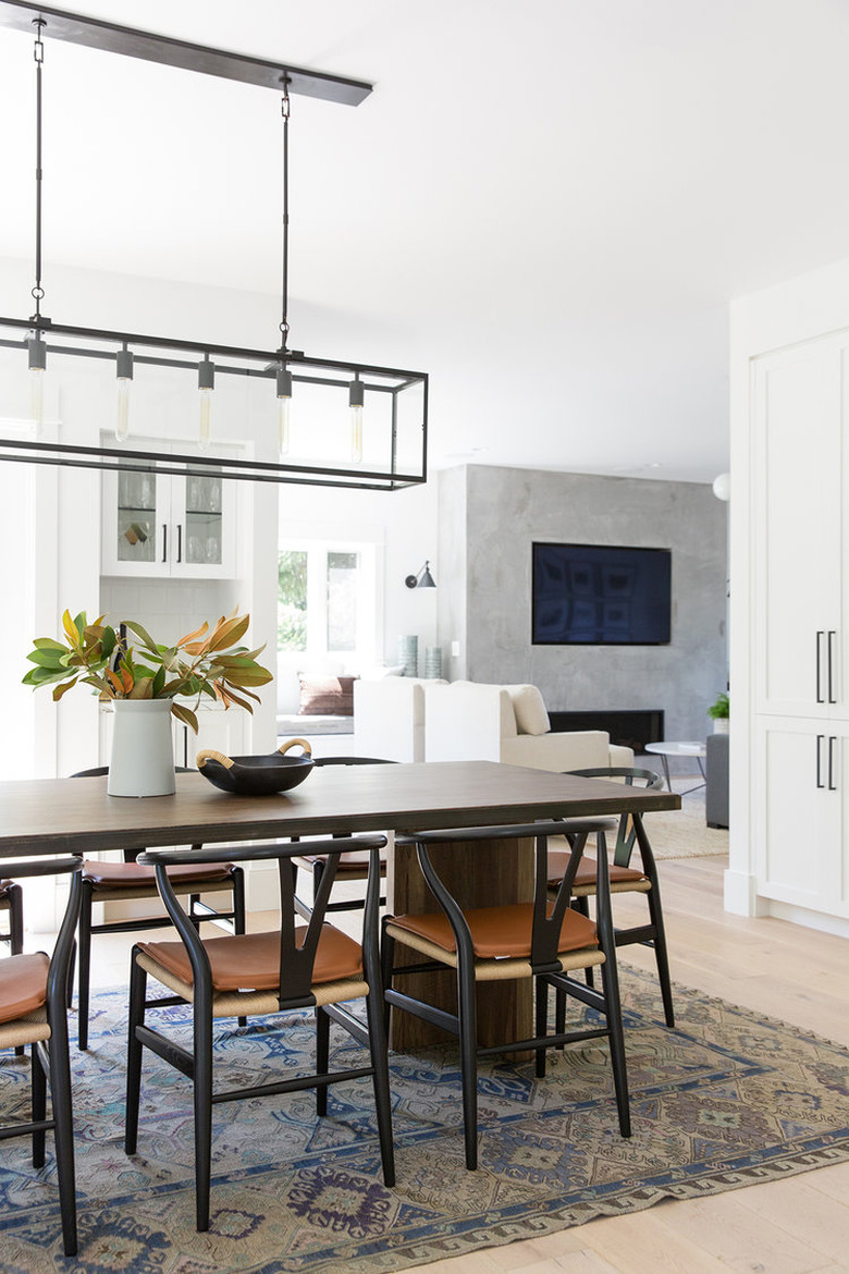 open concept dining room idea with wishbone chairs and rectangular chandelier that opens to living room and kitchen