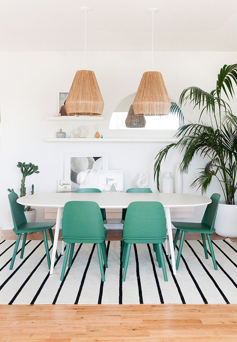 dining room lighting idea with woven jute pendants over oval table and green chairs