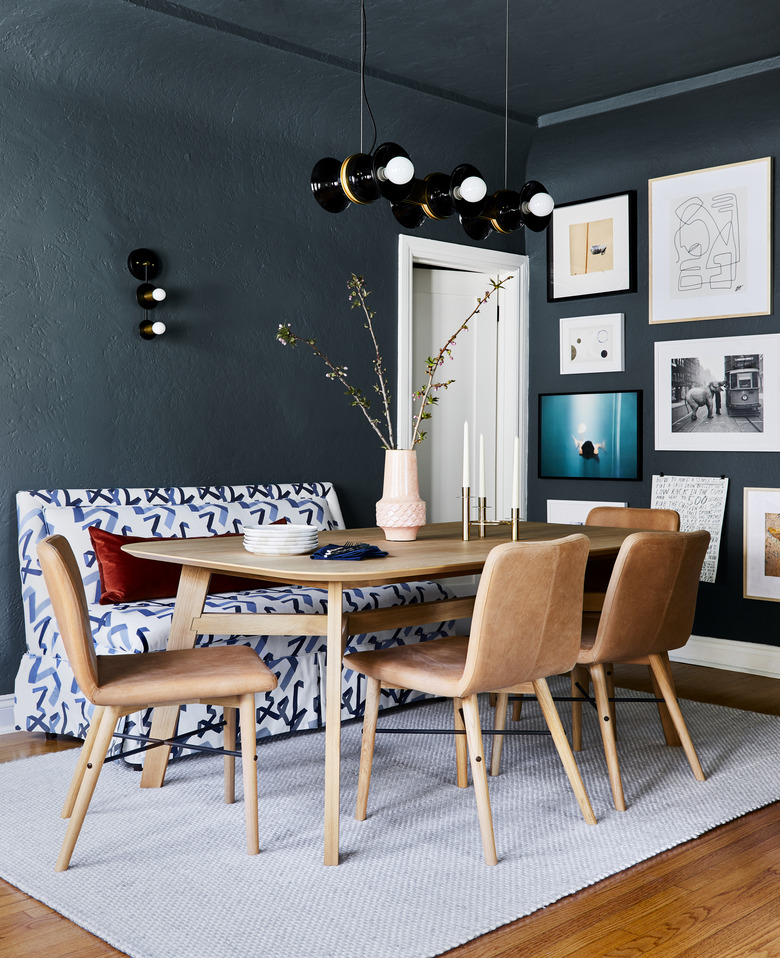 dining room lighting idea with chandelier above table and wall sconce on blue walls