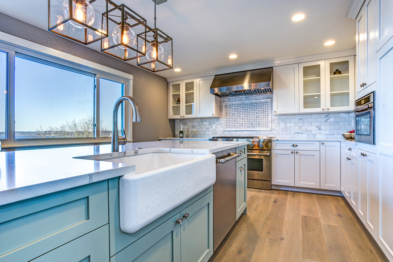 Beautiful kitchen room with green island and farm sink.