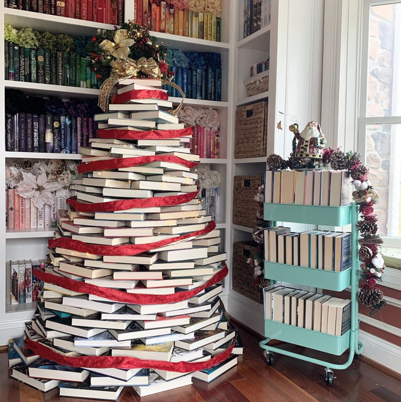 stacked-book DIY Christmas tree with red ribbon in library