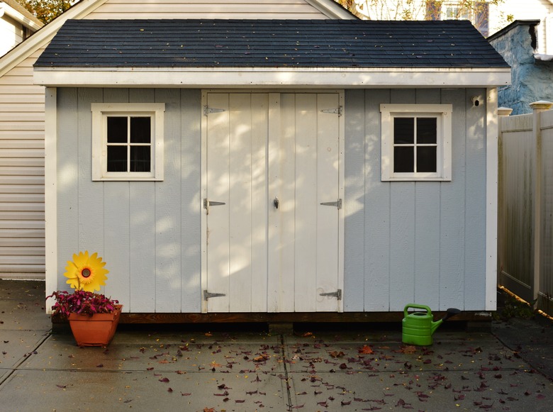 Blue and White Shed in Back Yard of House for Storage