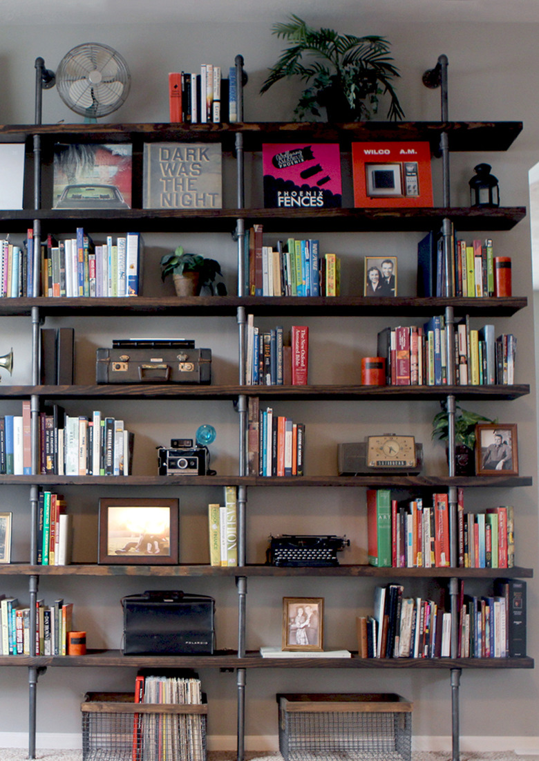 floor to ceiling pipe and wood DIY industrial bookshelf