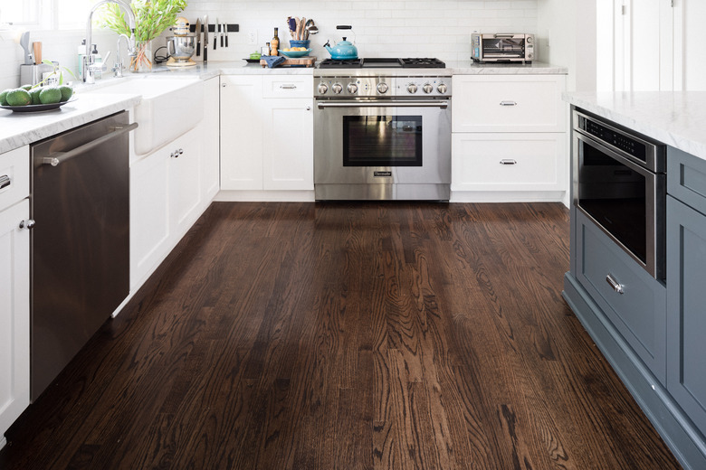 Dark wood floors in kitchen with blue and white cabinets