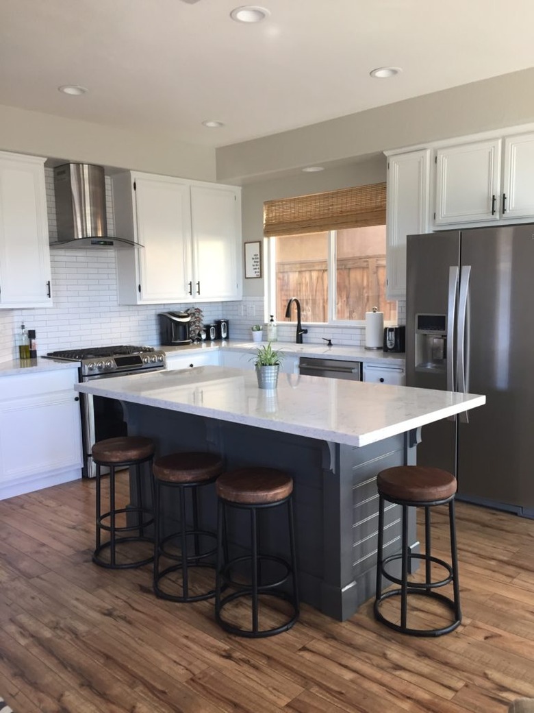 DIY kitchen island with corbels beadboard and white countertop with barstools