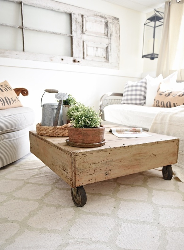 DIY rustic coffee table displaying a wood pallet and wheels in farmhouse living room