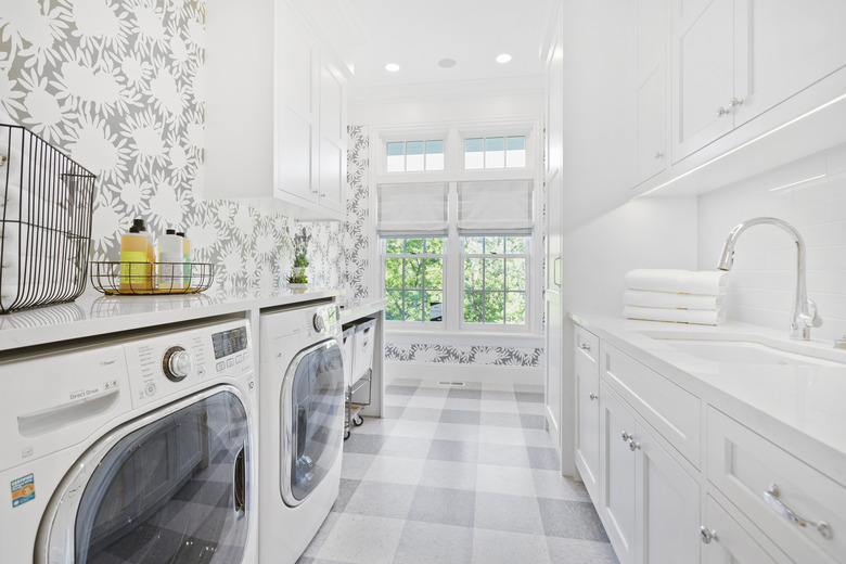 Decorative wallpaper and flooring in laundry room with new appliances.