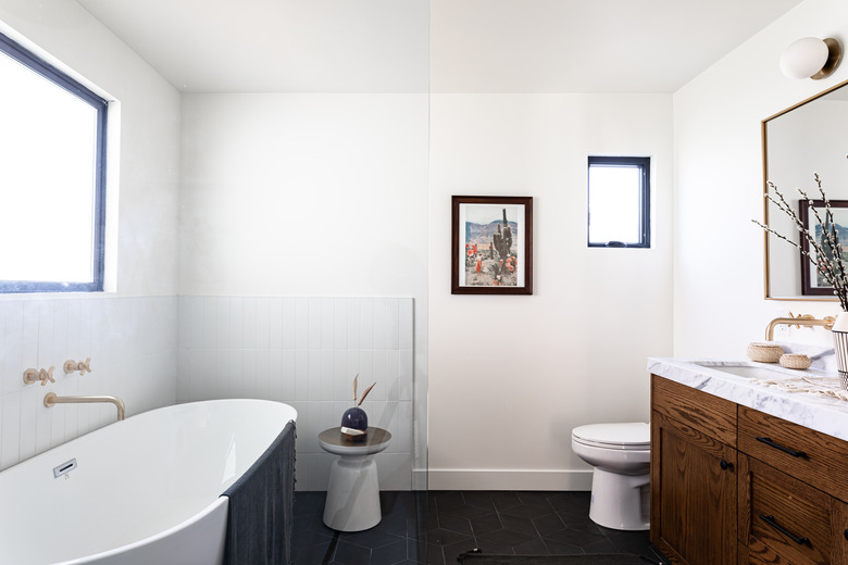 bathroom with bathroom vanity, toilet and stand-alone tub