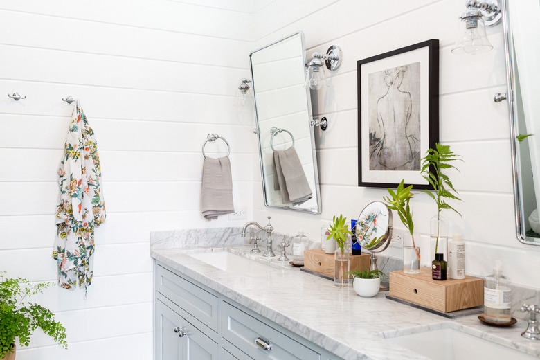 modern bathroom with tilted mirrors over double vanity