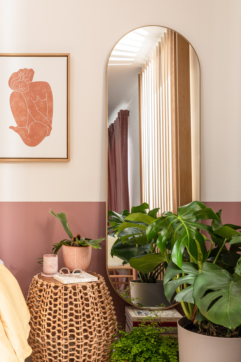 plants and full-sized mirror in a bedroom