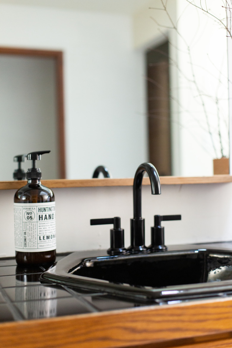 black tiled countertop with black drop in bathroom sink