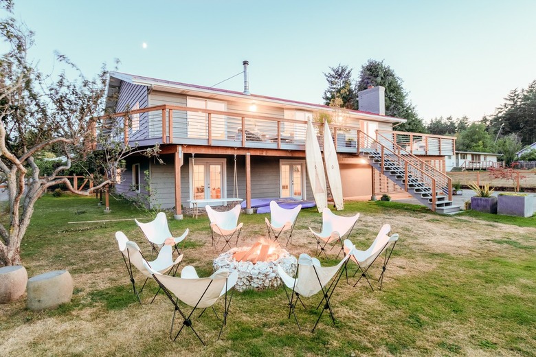 numerous butterfly chairs clustered around an oyster-shell fire pit