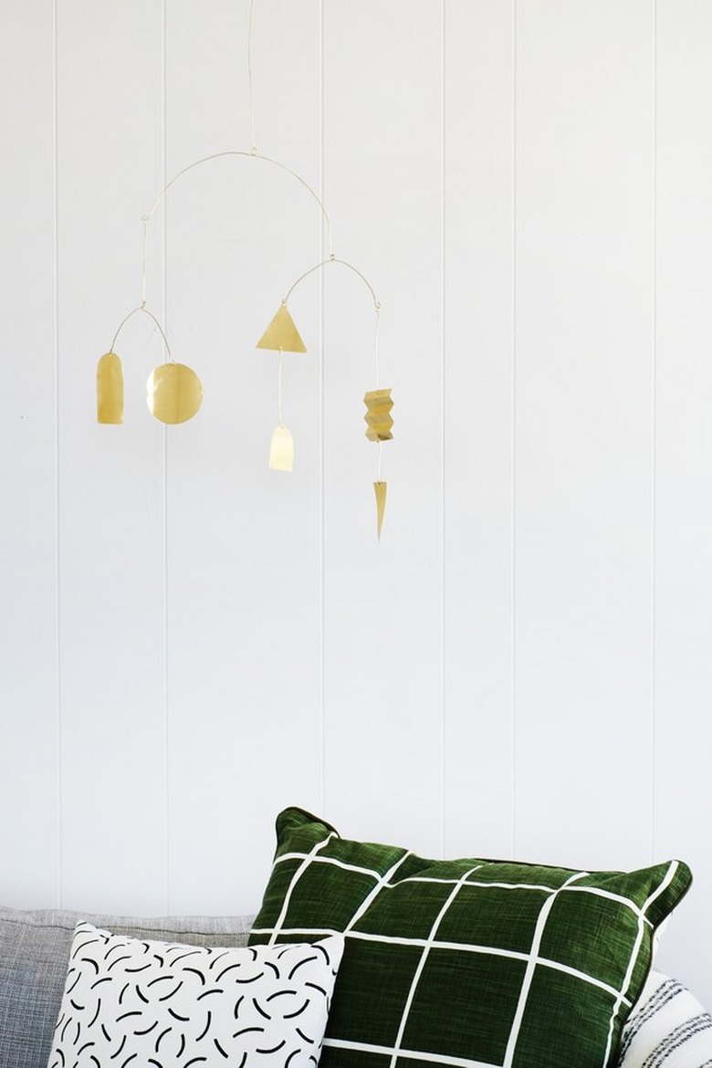 brass mobile hanging above a couch