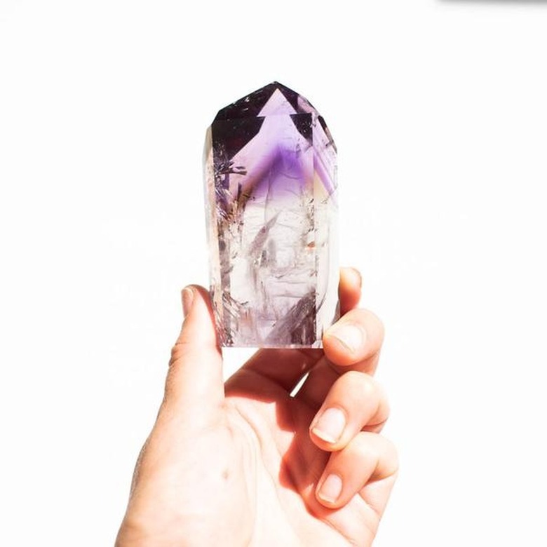 Hand holding piece of amethyst