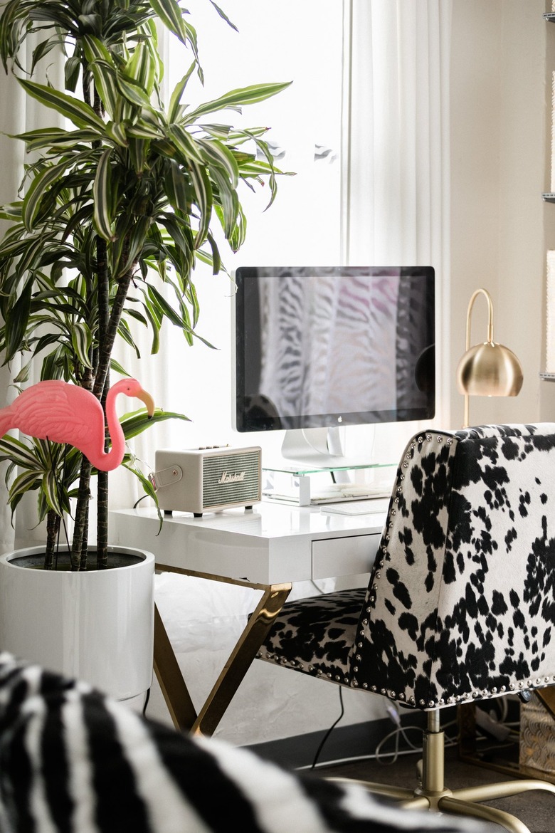 White desk with computer and cow patterened chair