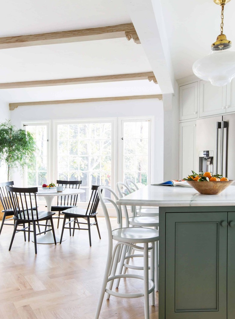 green and white eat-in kitchen with black table and chairs