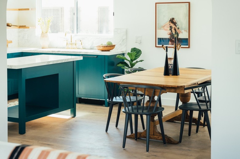 teal eat-in kitchen with wood table and black chairs