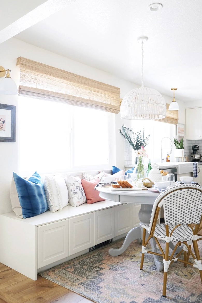 white eat-in kitchen with storage cabinets and bistro chairs