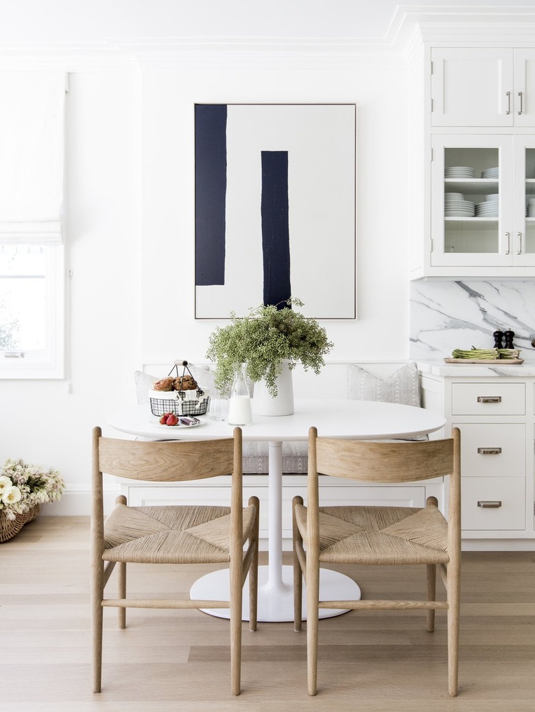 white eat-in kitchen with small table and chairs with modern artwork