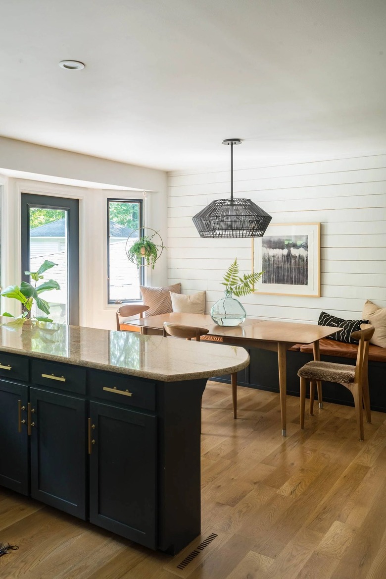 black and white eat-in kitchen with white shiplap wall and breakfast nook