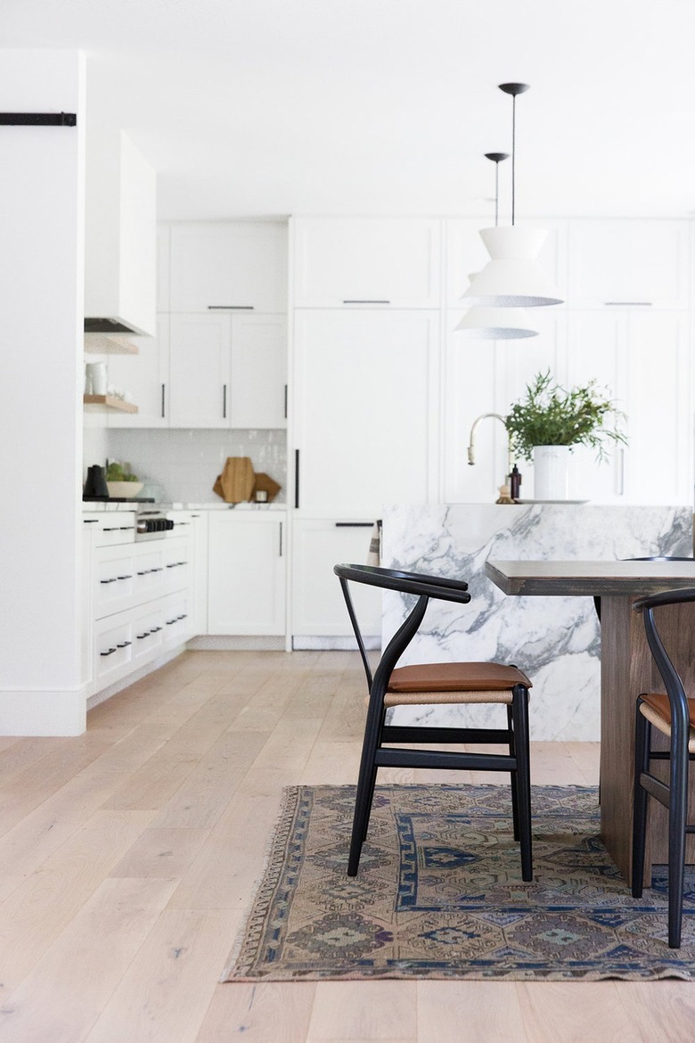 white eat-in kitchen with dining table over vintage area rug