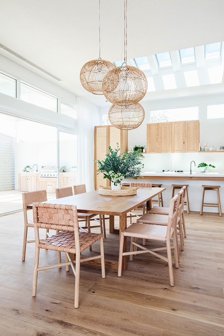 white and wood eat-in kitchen with pendant lights hanging over dining table