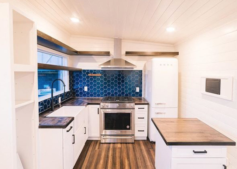 eco-friendly kitchen flooring with white cabinets and blue tile backsplash