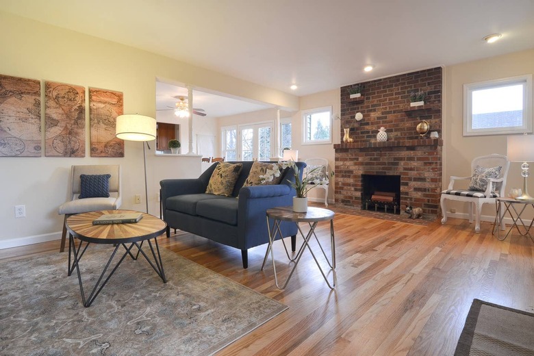 living room space in Craftsman home with brick fireplace