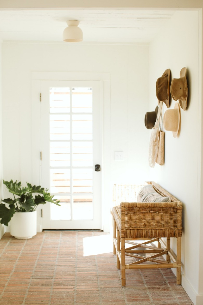 light-filled entryway with vintage hats hanging on the wall