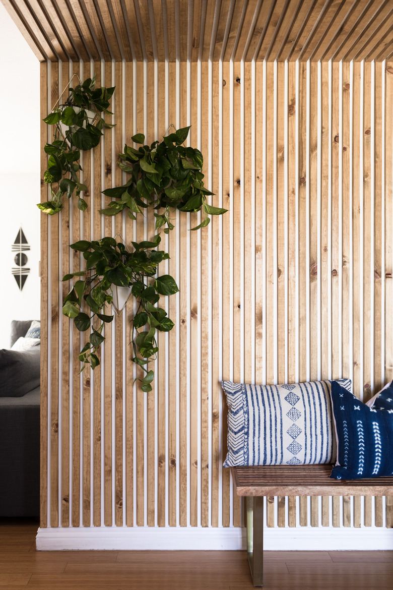 Entryway idea with wood plank accent wall and bench and potted plants