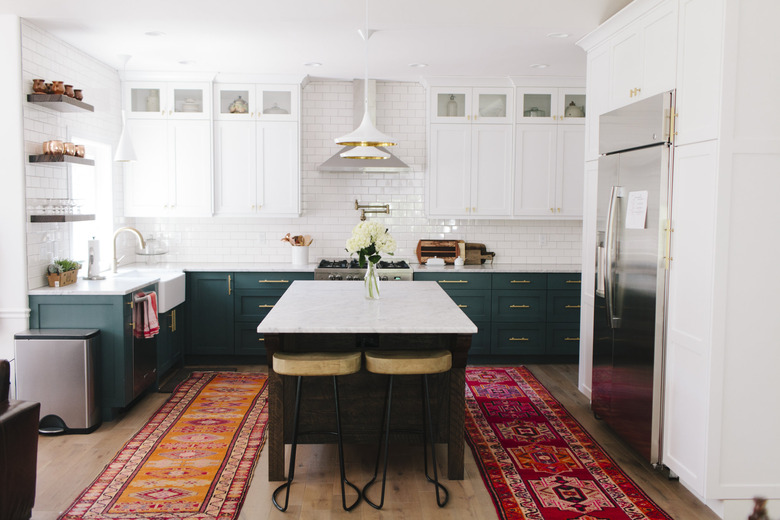 espresso kitchen island with green cabinets and colorful runners