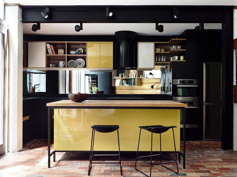 black and yellow cabinets with terra cotta kitchen flooring