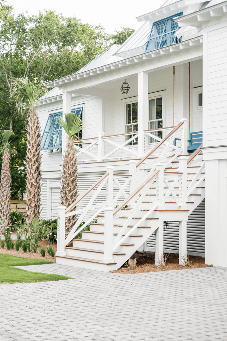 Blue and white exterior beach house colors with driveway and palm trees