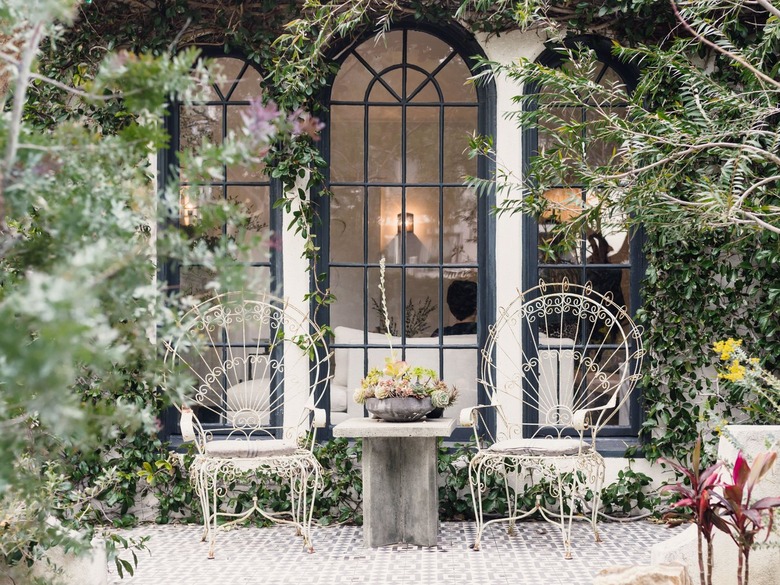 outdoor seating area in front of black iron arched exterior windows