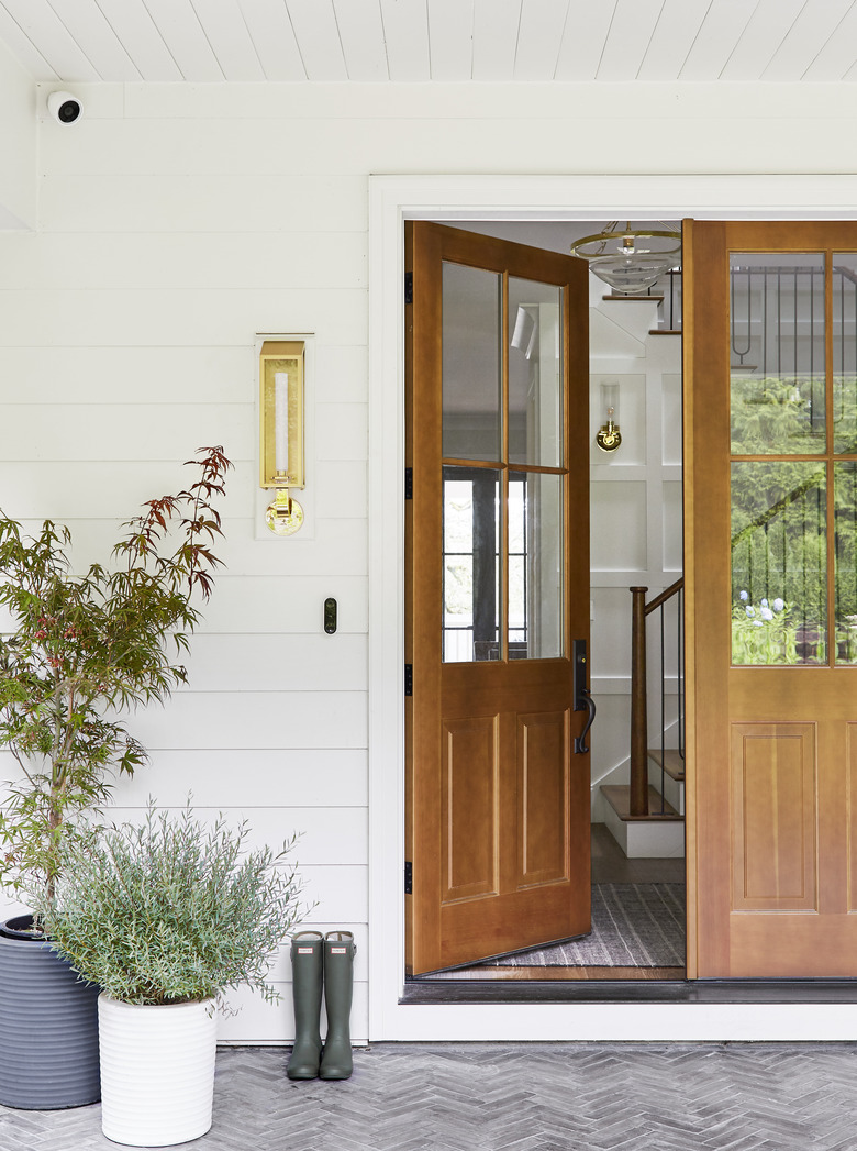 Exterior house light in brass next to wood front door