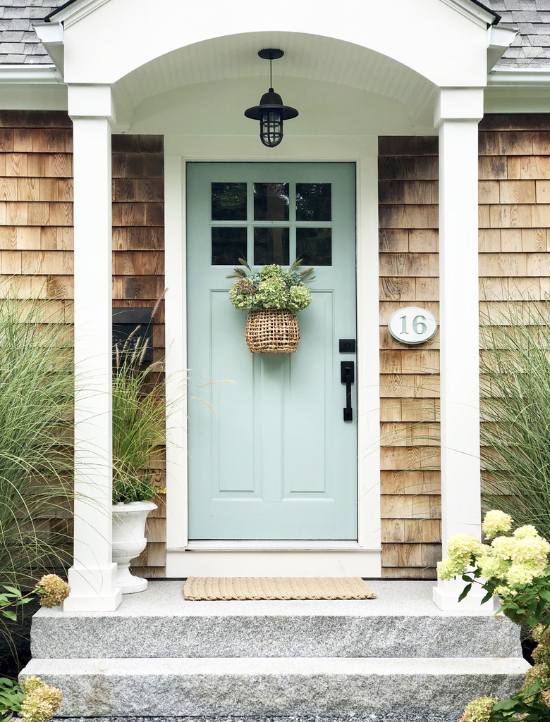 Pendant-style exterior house light in black with blue front door