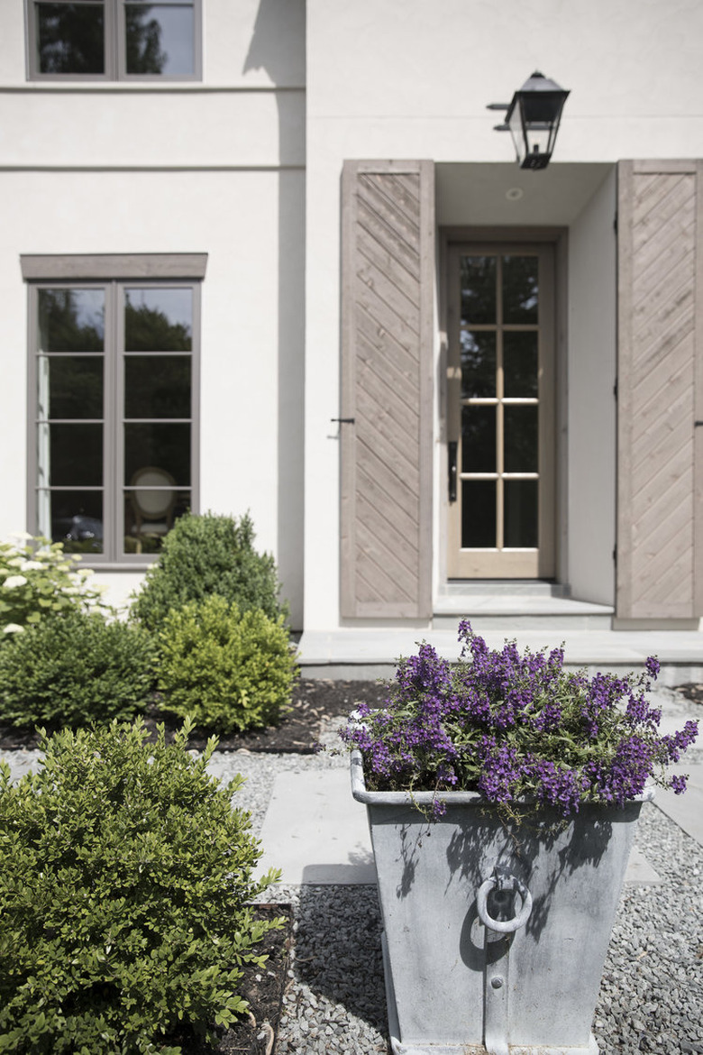 Beige exterior house shutters framing front doorway