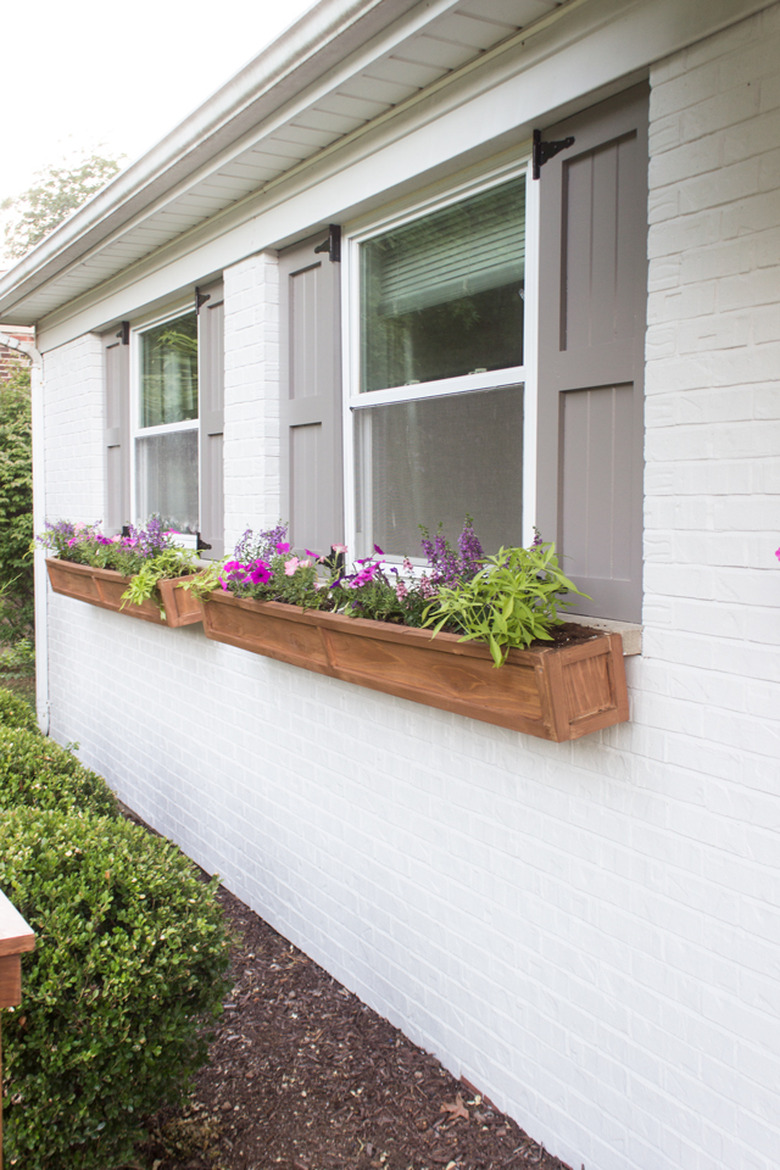 Gray exterior house shutters with cedar flower boxes