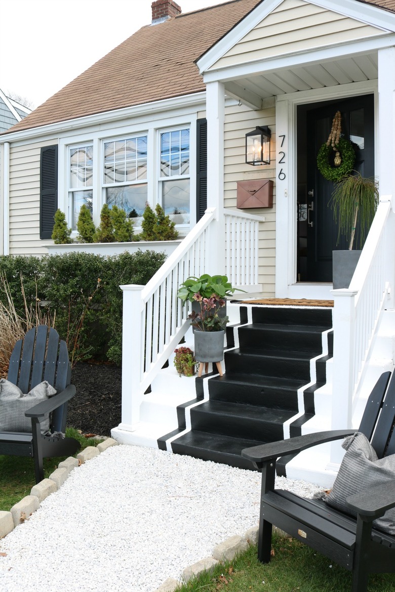 Black exterior house shutters with black and white painted steps and black front door