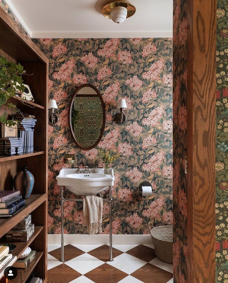 Bathroom with floral wallpaper, brown and white floors.