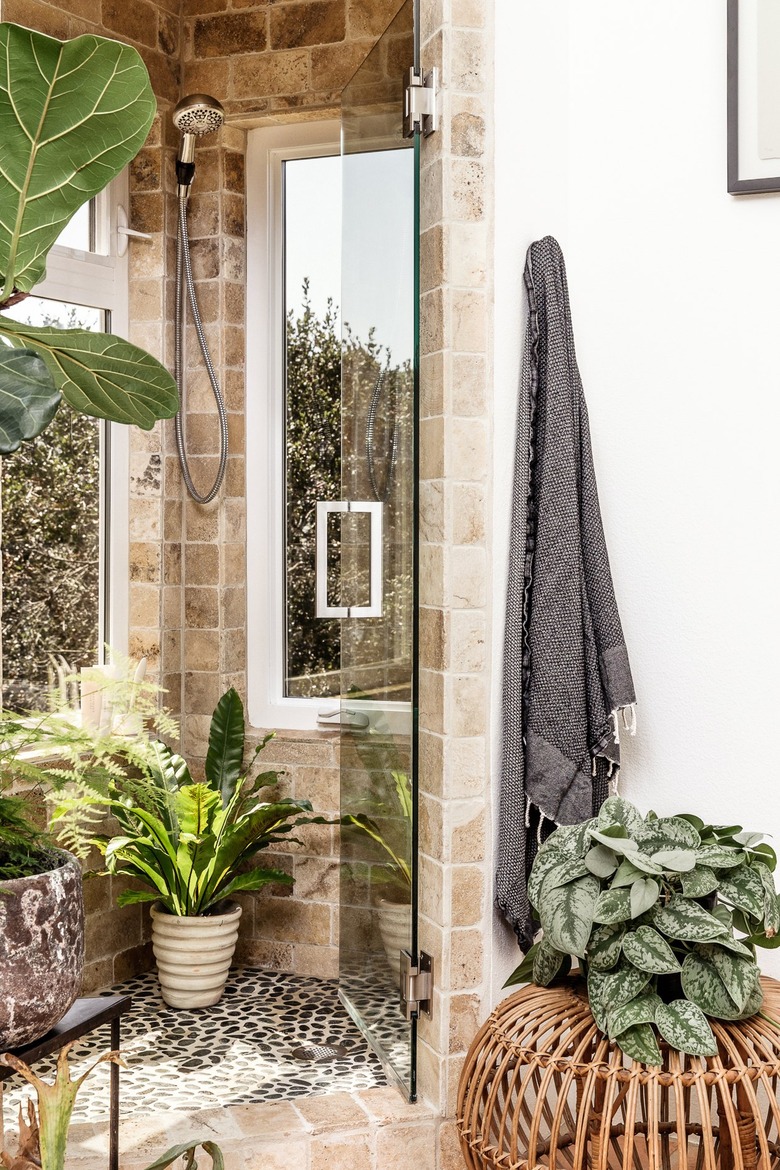 Bathroom with stone and marble shower, plants.