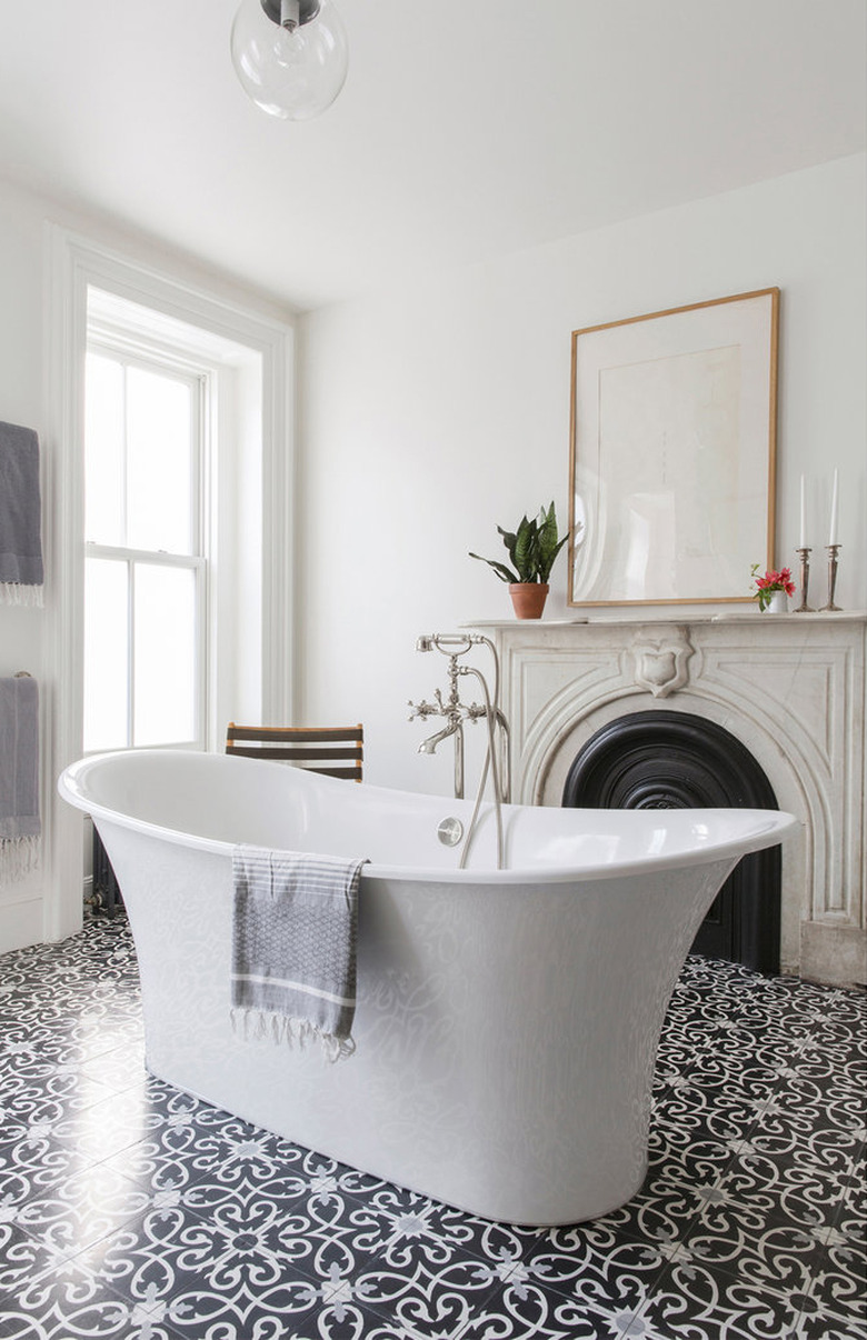 freestanding bathtub in the center of master bathroom with fireplace