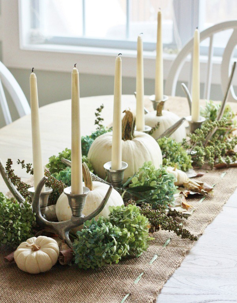 fall flower arrangement with white pumpkins, burlap runner and candlesticks