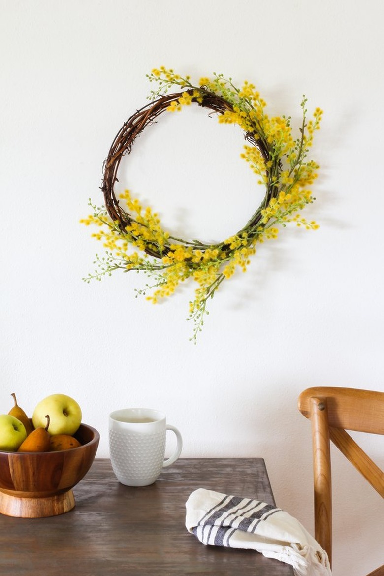 fall kitchen decor with grapevine and yellow wreath hanging above a kitchen table