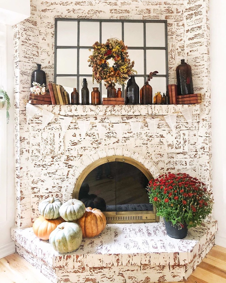 orange and green fall pumpkins on brick fireplace