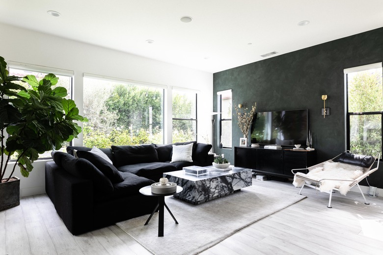 Black family room paint colors with marbled table and black fabric couch.